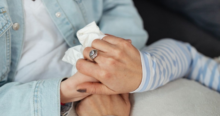 Twee vrouwen houden elkaars hand vast als steun