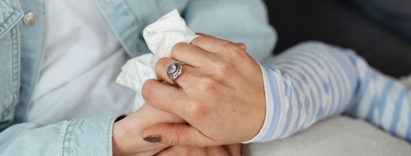 Twee vrouwen houden elkaars hand vast als steun