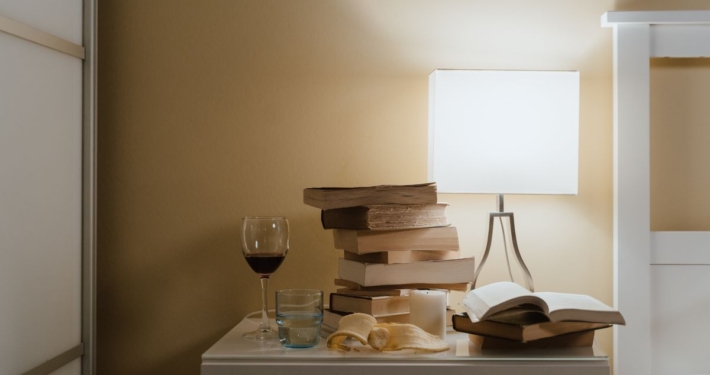 Nachtkastje met boeken, een lamp en een glas wijn, thrillers van Esther Verhoef