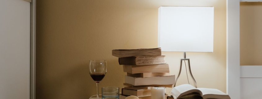Nachtkastje met boeken, een lamp en een glas wijn, thrillers van Esther Verhoef